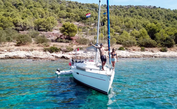 James and Danielle standing together on the front of their sailboat Nayru